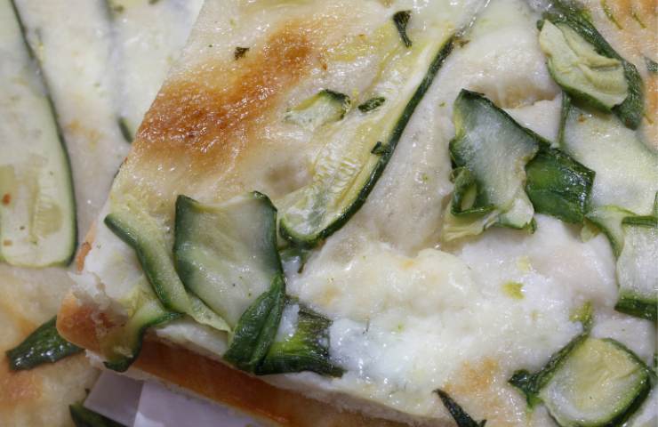 Una fetta dall'alto di focaccia ripiena di mozzarelle e zucchine