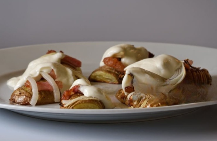 Delle patate al forno con bacon e besciamella in un piatto