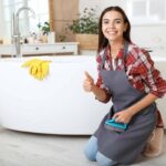 donna in ginocchio in bagno accanto alla vasca