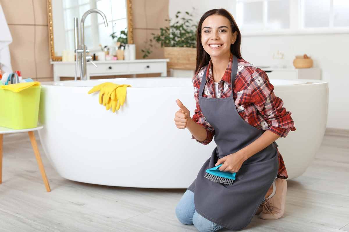 donna in ginocchio in bagno accanto alla vasca