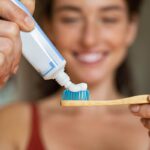 ragazza che mette il dentifricio sullo spazzolino