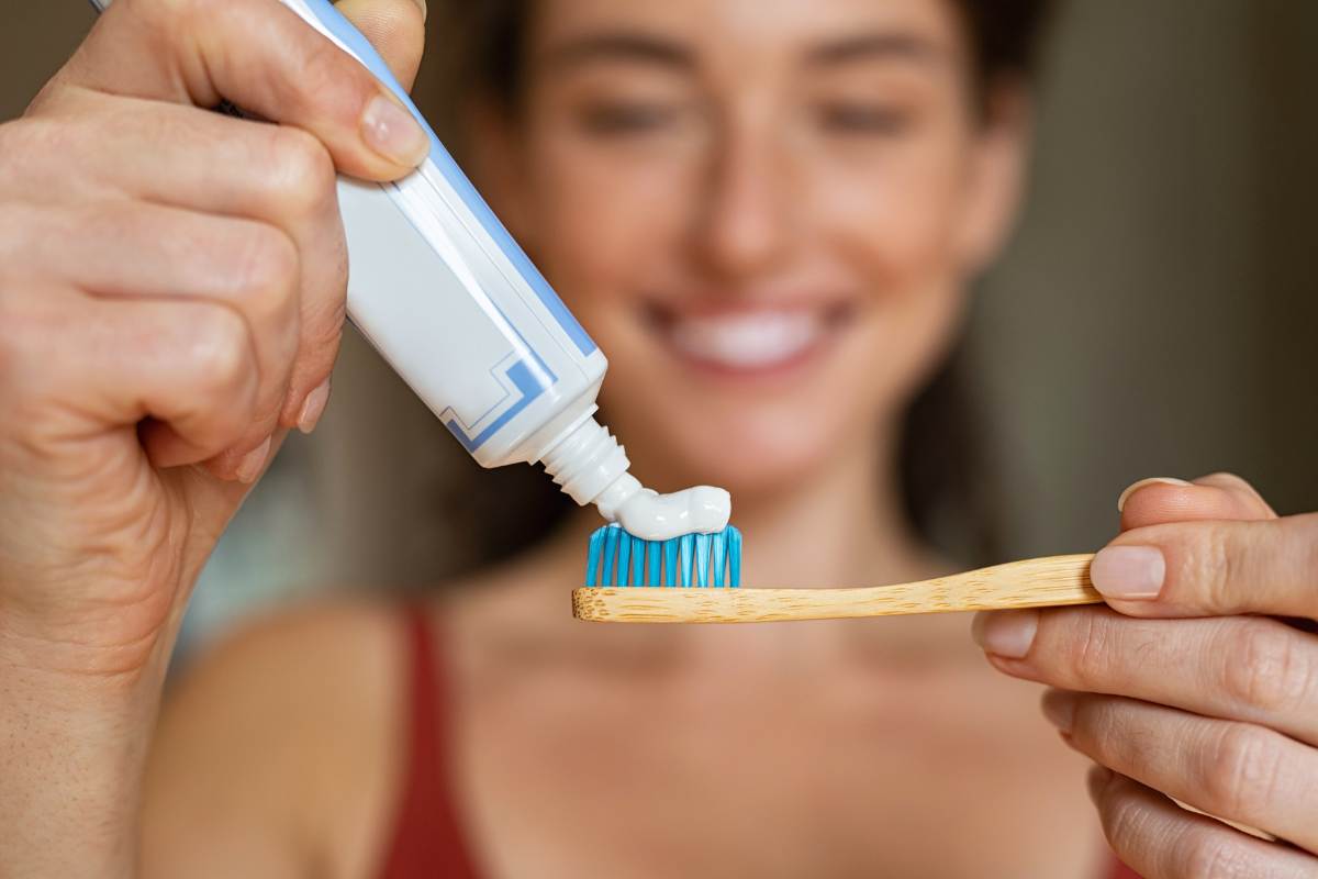 ragazza che mette il dentifricio sullo spazzolino