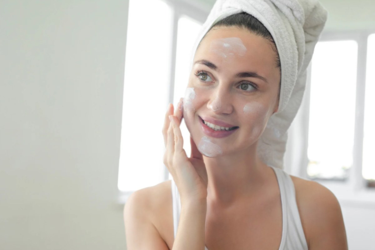 donna che mette la crema in viso