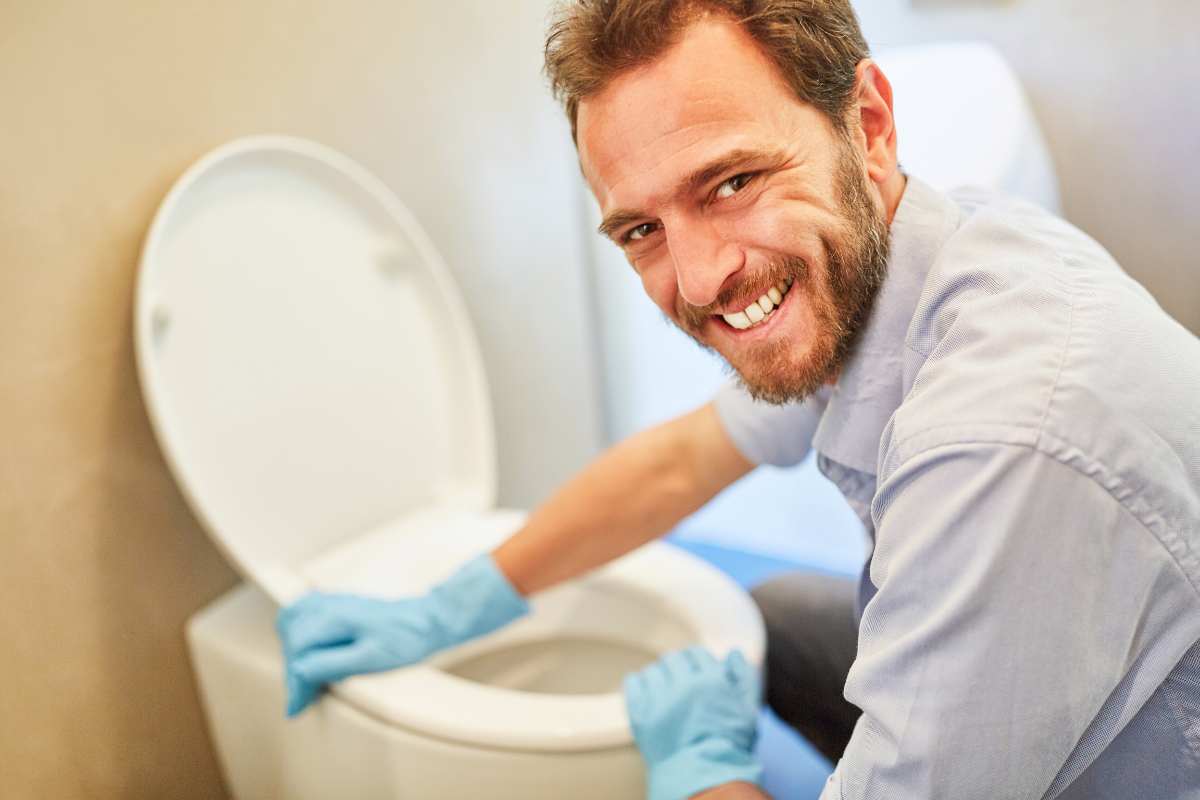 uomo pulisce il WC